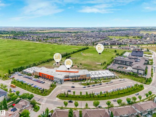 Aerial perspective showcasing a large commercial building with extensive parking, bordered by residential areas and green spaces - 1090 Armitage Crescent, Edmonton, AB 