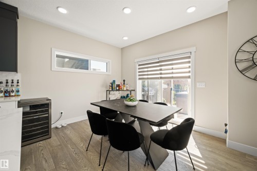 Dining area featuring recessed ceiling lighting, a large glass sliding door with horizontal blinds, a horizontal window, and wood-finish flooring - 12171 177 Avenue, Edmonton, AB 