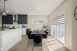 Spacious kitchen and dining area with light wood-finish flooring - 