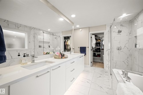 Contemporary bathroom featuring a dual vanity with white cabinetry, integrated sinks, and polished chrome fixtures - 12171 177 Avenue, Edmonton, AB 