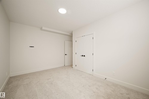 Neutral tone carpeted room featuring white walls, recessed ceiling lighting, and crisp white trim - 12171 177 Avenue, Edmonton, AB 