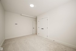 Neutral tone carpeted room featuring white walls, recessed ceiling lighting, and crisp white trim - 