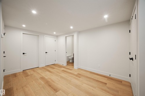 Spacious room featuring light wood-finish flooring, recessed lighting, and white walls - 12171 177 Avenue, Edmonton, AB 