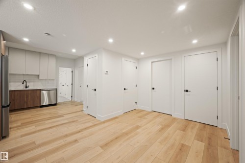 Open-concept living area with wood-finish flooring, recessed lighting, and multiple white panel doors - 12171 177 Avenue, Edmonton, AB 