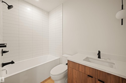 Modern bathroom featuring a white bathtub with subway tile surround and matte black fixtures - 12171 177 Avenue, Edmonton, AB 