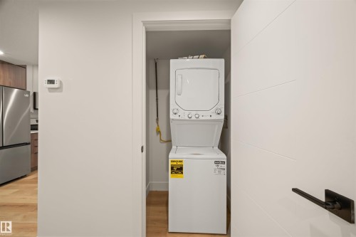 Dedicated laundry closet with a stacked washer and dryer, featuring light wood-finish flooring - 12171 177 Avenue, Edmonton, AB 
