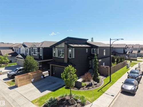 Contemporary two-story residence featuring dark siding, a dark trim roofline, and a prominent front entrance - 12171 177 Avenue, Edmonton, AB 