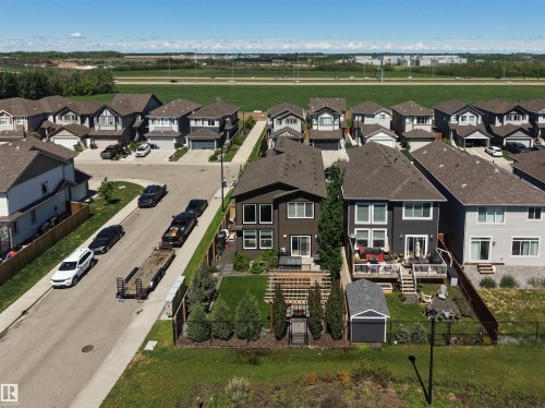 Rear exterior of a two-story residence featuring a dark gray facade with white trim, a second-story balcony, and a ground-level patio - 12171 177 Avenue, Edmonton, AB 