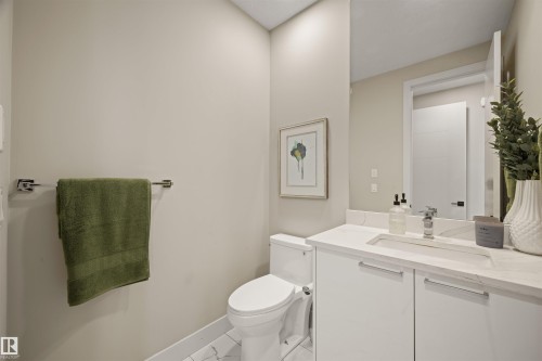 Contemporary bathroom featuring a white vanity with integrated sink, chrome faucet, and mirrored cabinet - 12171 177 Avenue, Edmonton, AB 