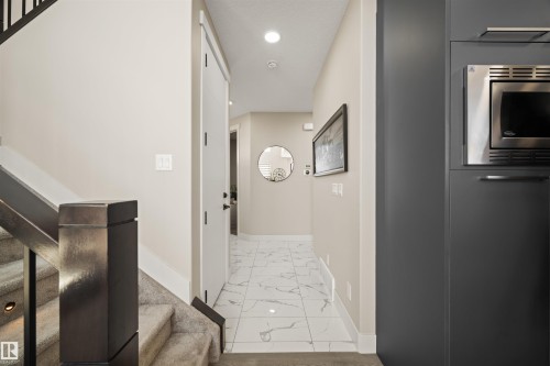 Entryway featuring large format tiled flooring, recessed lighting, and a built-in stainless steel microwave - 12171 177 Avenue, Edmonton, AB 