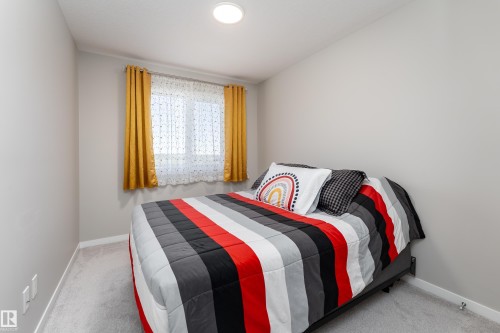 Bedroom featuring light grey walls, light grey carpet flooring, a recessed ceiling light, and a window with white trim - 2520 152 Avenue, Edmonton, AB 
