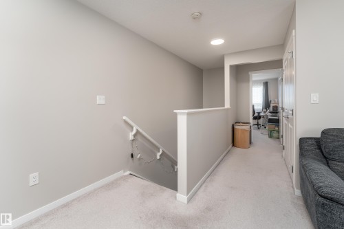 Carpeted hallway with a white painted railing and light gray walls - 2520 152 Avenue, Edmonton, AB 