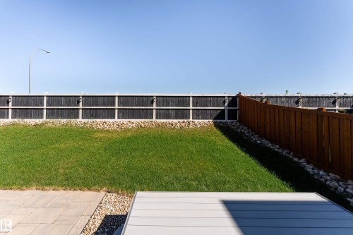 Expansive backyard featuring a manicured lawn, a two-tone privacy fence, and a wood privacy fence - 2520 152 Avenue, Edmonton, AB 
