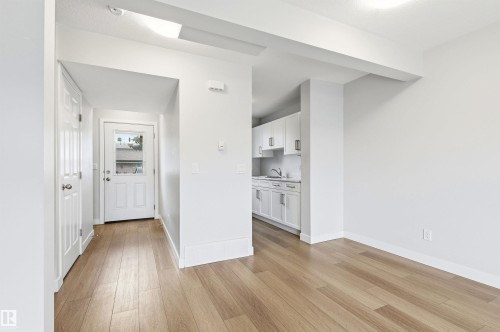 Bright open-concept living area with light wood-finish flooring - 18353 66 Avenue, Edmonton, AB 