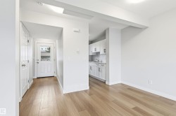 Bright open-concept living area with light wood-finish flooring - 