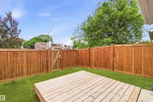 Private backyard space featuring a wooden privacy fence, a wooden deck, and artificial turf - 18353 66 Avenue, Edmonton, AB 