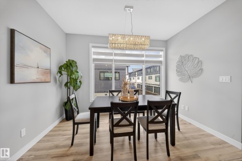Dining area featuring wood-finish flooring and a rectangular window with blinds - 52 1729 Keene Crescent, Edmonton, AB 