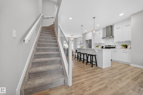 Staircase featuring plush grey carpeting and white handrails - 52 1729 Keene Crescent, Edmonton, AB 