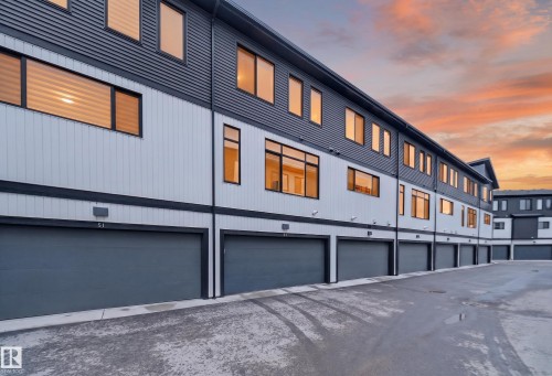 Modern multi-level townhome exterior featuring contemporary dark gray horizontal siding and light gray vertical siding - 52 1729 Keene Crescent, Edmonton, AB 