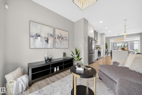 Open-concept living space featuring wood-finish flooring and recessed lighting - 52 1729 Keene Crescent, Edmonton, AB 