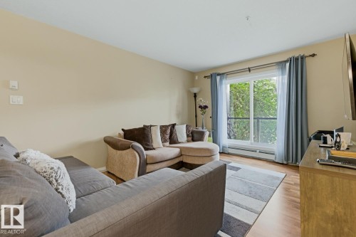 Living space featuring light beige walls and wood-finish flooring - 211 1204 156 Street Nw, Edmonton, AB 