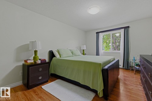 Bedroom featuring wood-finish flooring, a double-paned window, and a flush-mount ceiling light fixture - 211 1204 156 Street Nw, Edmonton, AB 