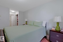 Bedroom with hard surface flooring, light-toned wall paint, and a built-in closet with double doors - 