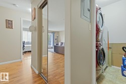 Entryway featuring wood-finish flooring, a full-length mirrored closet door, and neutral-toned walls - 