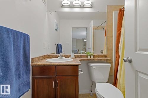 Bathroom featuring a single-sink vanity with wood-finish cabinetry and a speckled countertop - 211 1204 156 Street Nw, Edmonton, AB 