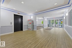 Spacious common area featuring wood-finish flooring, recessed lighting, and a prominent elevator - 