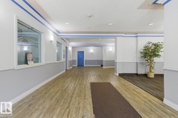 Spacious common area featuring wood-finish flooring, recessed lighting, and wall-mounted sconces - 