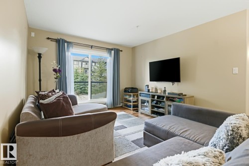 Living area featuring light beige walls and wood-finish flooring - 211 1204 156 Street Nw, Edmonton, AB 