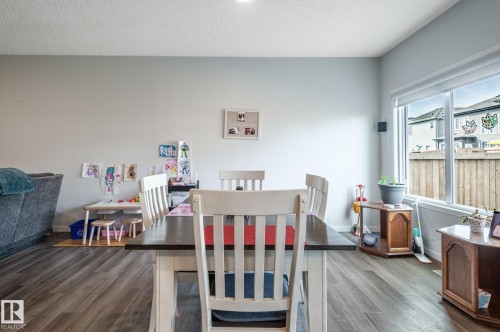 Spacious room featuring wood-finish flooring, light-toned walls, and a large window - 17562 63A Street, Edmonton, AB 