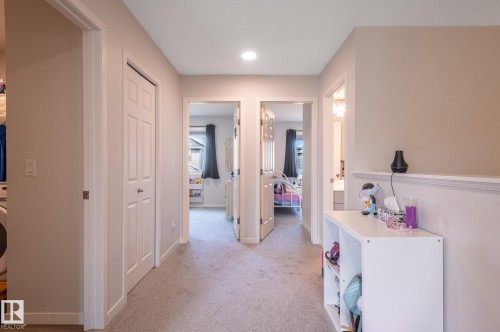 Carpeted hallway featuring a neutral color palette, recessed lighting, and multiple paneled doors - 17562 63A Street, Edmonton, AB 