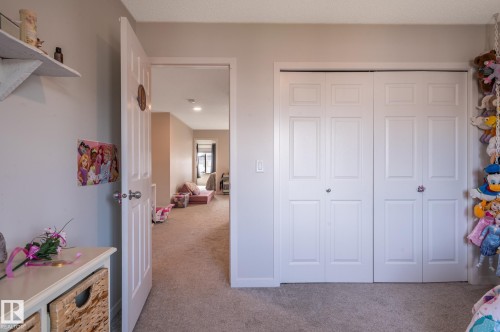 White bi-fold closet doors with panel detailing, light neutral wall paint, and plush carpeting - 17562 63A Street, Edmonton, AB 