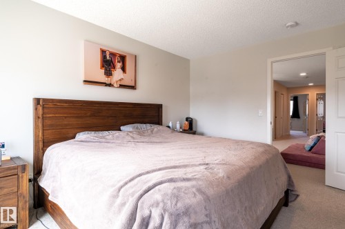 Neutral-toned bedroom featuring wall-to-wall carpeting and a textured ceiling - 17562 63A Street, Edmonton, AB 