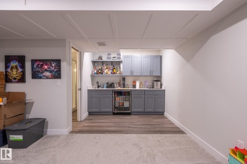 Wet bar featuring gray cabinetry, a beverage refrigerator, and open shelving - 17562 63A Street, Edmonton, AB 