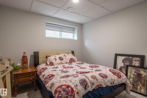 Carpeted room featuring a drop ceiling with recessed lighting, a window with horizontal blinds, and neutral wall paint - 17562 63A Street, Edmonton, AB 