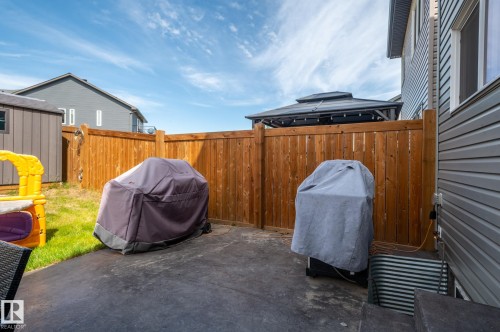 Backyard space featuring a concrete patio, wood privacy fence, and a gazebo structure - 17562 63A Street, Edmonton, AB 
