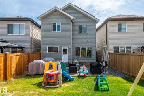 Fenced backyard featuring a manicured lawn, a paved patio area, and a gravel border - 17562 63A Street, Edmonton, AB 