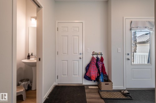 Foyer with wood-finish flooring, a six-panel door, and a door with an integrated window - 17562 63A Street, Edmonton, AB 