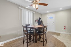 Entry area featuring a white panel door with an arched window, wood-finish flooring, and a ceiling fan with light fixture - 