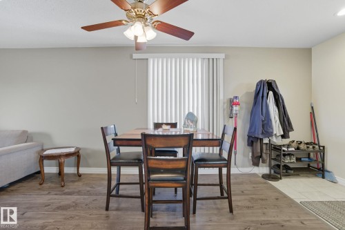 Dining area featuring wood-finish flooring and a ceiling fan with integrated lighting - 14239 53 Street, Edmonton, AB 