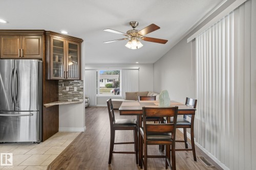 Open-concept dining area featuring wood-finish flooring and a ceiling fan - 14239 53 Street, Edmonton, AB 