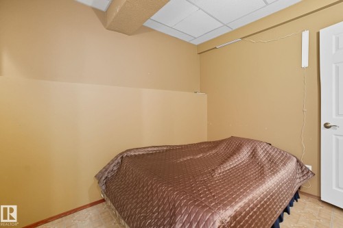 Recessed ceiling with acoustic tiles, neutral wall paint, white interior door, and light-toned floor tiles - 14239 53 Street, Edmonton, AB 
