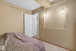 Recessed wall niche with two wall-mounted sconces, neutral wall finishes, white paneled door, and patterned tile flooring - 
