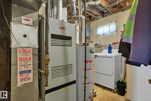 Utility area featuring a water heater, furnace, and exposed ceiling joists - 14239 53 Street, Edmonton, AB 