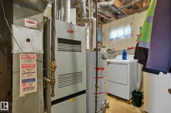 Utility area featuring a water heater, furnace, and exposed ceiling joists - 