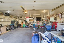 Two-car garage featuring a concrete floor, built-in shelving, mounted lighting, and a utility window - 