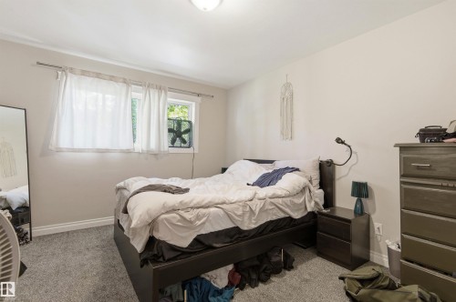 Carpeted bedroom featuring two windows, recessed lighting, and ample wall space - 7412/7414 83 Avenue, Edmonton, AB 